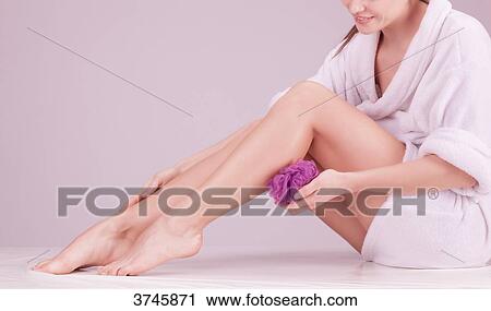 Young woman using a sponge massage on her leg View Large Photo Image Stock Image - Young woman using a sponge massage on her leg. Fotosearch