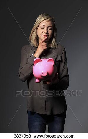 Young woman with money pig View Large Photo Image Stock Photo - Young woman with money pig. Fotosearch