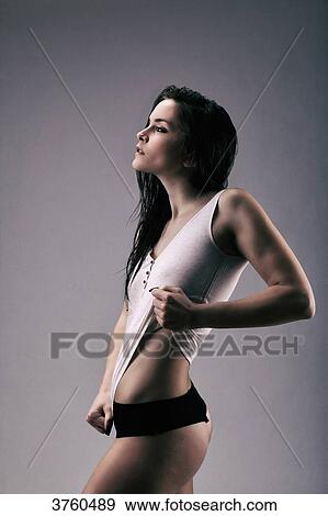 Stock Photo - Athletic young girl in profile stretching his shirt. Fotosearch