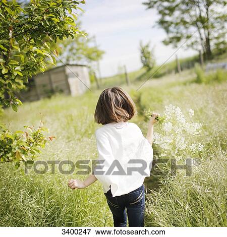 Back view of a little girl running in the countryside with a bunch of flowers in her hand View Large Photo Image Stock Photo - Back view of a little girl running in the countryside with a bunch of flowers in her hand. Fotosearch