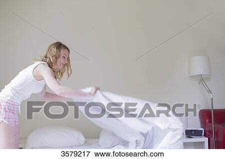 Blonde woman making bed View Large Photo Image Stock Photo - Blonde woman making bed. Fotosearch