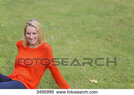 Blonde woman sitting in the park and smiling at camera View Large Photo Image Stock Photo - Blonde woman sitting in the park and smiling at camera. Fotosearch