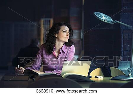 Brown-haired young woman in a library, thinking. View Large Photo Image Stock Image - Brown-haired young woman in a library, thinking.. Fotosearch