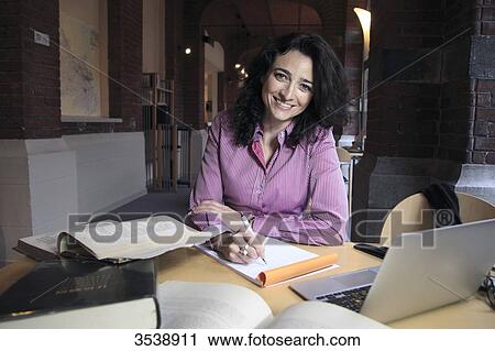 Brown-haired young woman in a library. View Large Photo Image Stock Image - Brown-haired young woman in a library.. Fotosearch