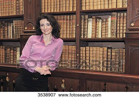 Brown-haired young woman in a library of old books. View Large Photo Image Stock Photo - Brown-haired young woman in a library of old books.. Fotosearch