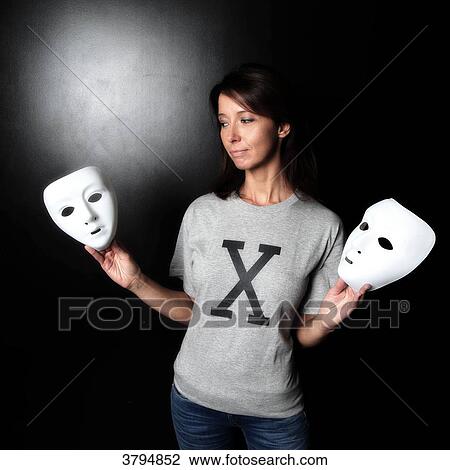 Brown woman in a studio wearing a T-shirt with an X and holding a mask in each hand. Conceptual image on the theme Born under X. View Large Photo Image Stock Image - Brown woman in a studio wearing a T-shirt with an X and holding a mask in each hand. Conceptual image on the theme Born under X.. Fotosearch