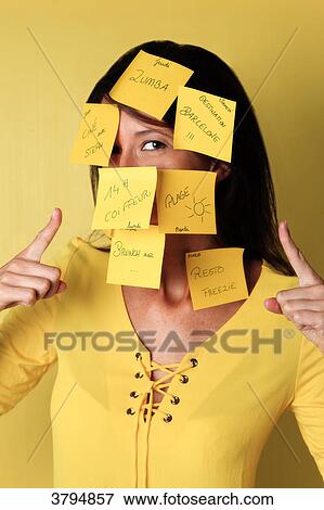 Brown woman in studio with post it of appointments of leisure on the face. View Large Photo Image Stock Photo - Brown woman in studio with post it of appointments of leisure on the face.. Fotosearch