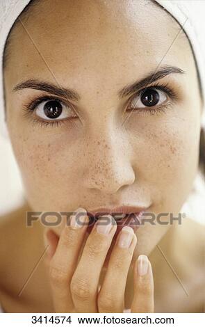 Close-up of a dark haired young woman, with her hand held to her face View Large Photo Image Picture - Close-up of a dark haired young woman, with her hand held to her face. Fotosearch