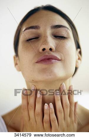 Close-up of a dark haired young woman smoothing her neck View Large Photo Image Stock Photo - Close-up of a dark haired young woman smoothing her neck. Fotosearch