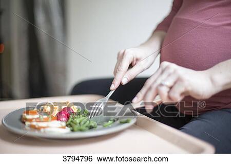 Close up of a pregnant woman eating a plate of salad and vegetable. View Large Photo Image Stock Photograph - Close up of a pregnant woman eating a plate of salad and vegetable.. Fotosearch