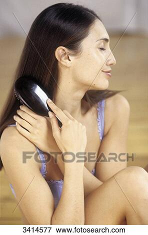 Dark haired young woman with her eyes closed, brushing her hair View Large Photo Image Stock Photo - Dark haired young woman with her eyes closed, brushing her hair. Fotosearch