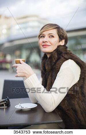 Daydreaming woman enjoying a coffee outdoors View Large Photo Image Stock Image - Daydreaming woman enjoying a coffee outdoors. Fotosearch