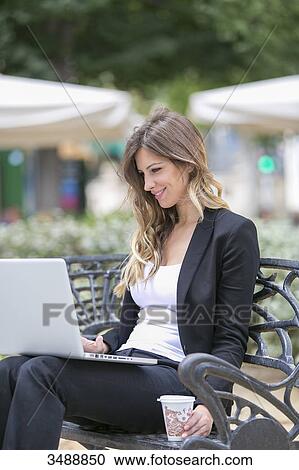 Executive woman with laptop sitting in a bank View Large Photo Image Stock Image - Executive woman with laptop sitting in a bank. Fotosearch