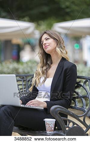 Executive woman with laptop sitting in a bank View Large Photo Image Stock Image - Executive woman with laptop sitting in a bank. Fotosearch