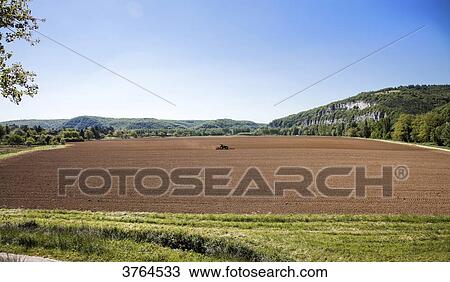 Stock Image - Farmer plows his fields, Saint Cirq, Lot, Languedoc-Roussillon, Midi-Pyrenees, France. Fotosearch