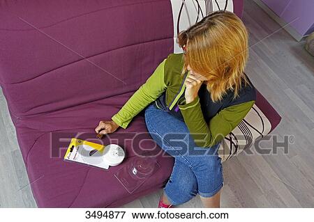 France around Paris, 42 year old woman trying to unwrap a smoke detector. View Large Photo Image Stock Photo - France around Paris, 42 year old woman trying to unwrap a smoke detector.. Fotosearch