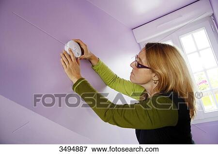 France, around Paris, 42 year old woman installing a smoke detector. View Large Photo Image Stock Photo - France, around Paris, 42 year old woman installing a smoke detector.. Fotosearch
