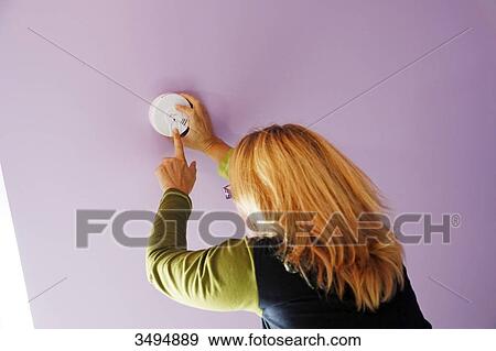 France, Around Paris, 42 year old woman in the process of installing and testing the ceiling smoke detector. View Large Photo Image Stock Photo - France, Around Paris, 42 year old woman in the process of installing and testing the ceiling smoke detector.. Fotosearch