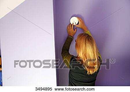 France, around Paris, 42 year old woman trying to install a smoke detector next to a chimney. View Large Photo Image Stock Photography - France, around Paris, 42 year old woman trying to install a smoke detector next to a chimney.. Fotosearch