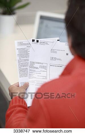 France, Back view of a man holding his tax notice View Large Photo Image Stock Photo - France, Back view of a man holding his tax notice. Fotosearch