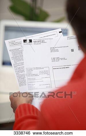France, Back view of a man holding his tax notice View Large Photo Image Stock Photograph - France, Back view of a man holding his tax notice. Fotosearch
