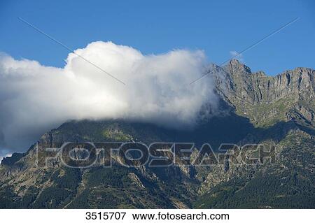 Stock Photo - France. Hautes Alpes. Landscape of the Champsaur. Cloud on a mountain in summer. Fotosearch