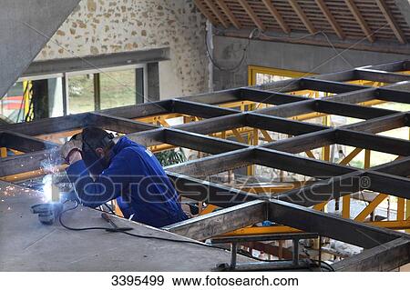 Stock Photo - France, House building, assembly and metal-arc welding. Fotosearch
