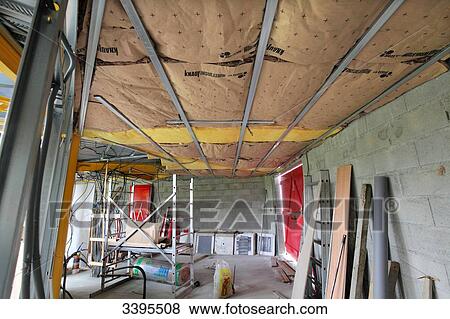 Stock Photo - France, House building, ceiling insulation with glass wool panels on suspended metal rails. Fotosearch