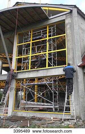 France, House building, handling safety with a lift machine, installation of large aluminium windows View Large Photo Image Stock Photo - France, House building, handling safety with a lift machine, installation of large aluminium windows. Fotosearch