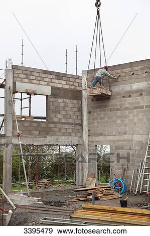 France, House building, raising the house's walls. Safety problem with the handling by construction equipment. Breach of security: mason in the bucket without helmet View Large Photo Image Stock Photo - France, House building, raising the house's walls. Safety problem with the handling by construction equipment. Breach of security: mason in the bucket without helmet. Fotosearch