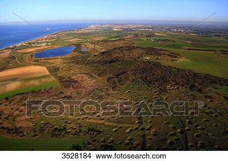 France, Norhern France, Pas-de-Calais. Town of Sangatte, Bleriot-Plage. Blanc-Nez Cape. Noires-Mottes, ground riddled with bomb holes. Front Pignon Lake, the fillage of Sangatte and Calais in the background. View Large Photo Image Picture - France, Norhern France, Pas-de-Calais. Town of Sangatte, Bleriot-Plage. Blanc-Nez Cape. Noires-Mottes, ground riddled with bomb holes. Front Pignon Lake, the fillage of Sangatte and Calais in the background.. Fotosearch