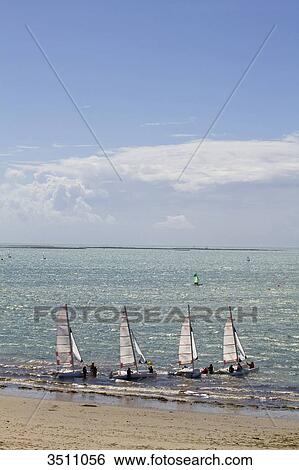 Stock Photograph - France, North-Western France, Ile de Noirmoutier, beach of la Cabane, group of teenagers on catamarans. Fotosearch