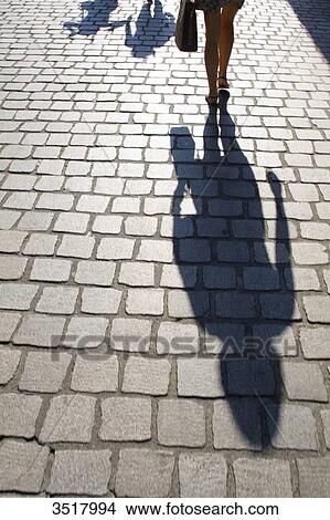 Picture - France, North Western France, Nantes, shade of a woman moving away.. Fotosearch