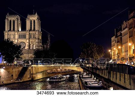 Stock Image - France, Paris, night view of the Notre-Dame Cathedral and banks of the Seine. Fotosearch