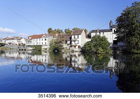 Stock Photograph - France, Seine and Marne. Nemours. City center. The Loing river in the foreground.. Fotosearch