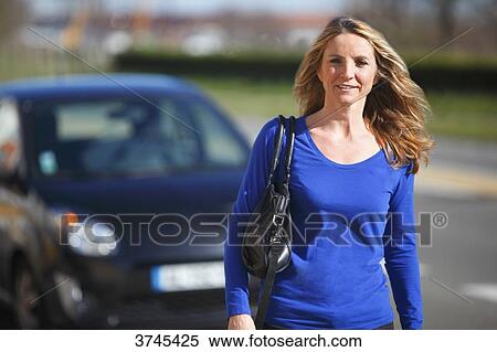 Stock Photography - France, woman in front of her car.. Fotosearch
