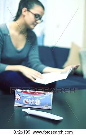 Stock Photo - France, young woman at home using Hiv test.. Fotosearch