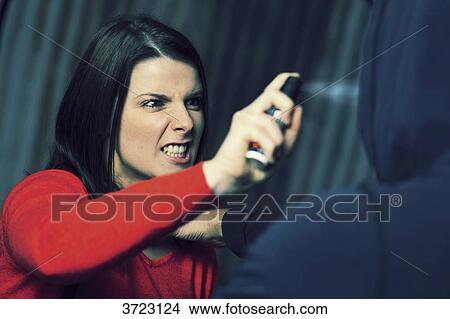 Picture - France, young woman with lachrymatory aerosol.. Fotosearch