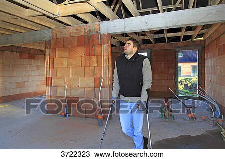 France, young working person with crutches in a house in construction. View Large Photo Image Stock Image - France, young working person with crutches in a house in construction.. Fotosearch