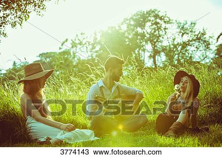 Group of young hipster sitting in the grass, playing guitar View Large Photo Image Stock Image - Group of young hipster sitting in the grass, playing guitar. Fotosearch