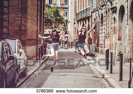 joy jump of two young women on a street in the city center View Large Photo Image Stock Photo - joy jump of two young women on a street in the city center. Fotosearch