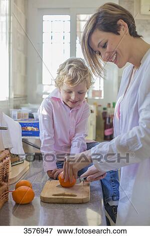 Mother and son doing orange juice in the kitchen View Large Photo Image Stock Photo - Mother and son doing orange juice in the kitchen. Fotosearch
