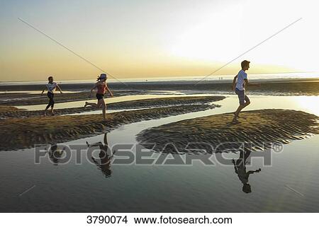 Normandy, Three kids playing on the beach View Large Photo Image Picture - Normandy, Three kids playing on the beach. Fotosearch