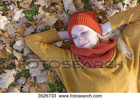 Pensive blonde woman lying in park in autumn View Large Photo Image Stock Image - Pensive blonde woman lying in park in autumn. Fotosearch