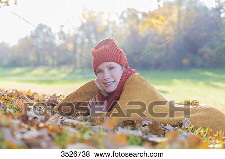 Pensive blonde woman lying in park in autumn View Large Photo Image Stock Photo - Pensive blonde woman lying in park in autumn. Fotosearch