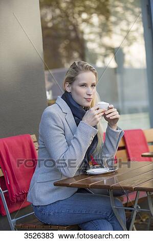 Pensive pretty woman enjoying a cup of coffee in city center View Large Photo Image Stock Image - Pensive pretty woman enjoying a cup of coffee in city center. Fotosearch