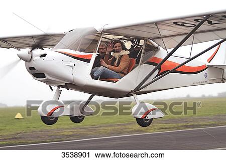 Stock Image - Pilot young woman flying a microlight.. Fotosearch