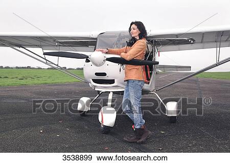 Pilot young woman in front of her microlight on the runway. View Large Photo Image Stock Photo - Pilot young woman in front of her microlight on the runway.. Fotosearch