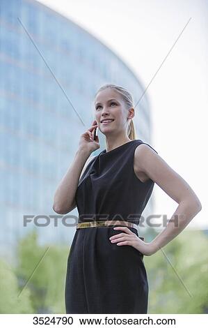Portrait of a business woman with mobile in front of an office building View Large Photo Image Stock Image - Portrait of a business woman with mobile in front of an office building. Fotosearch