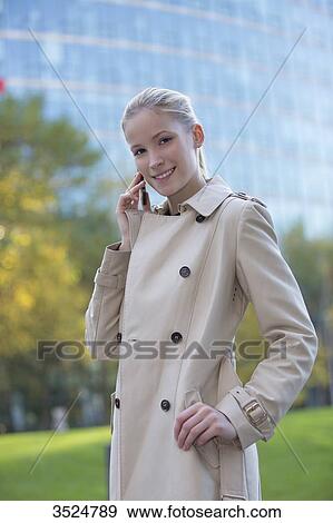 Stock Photo - Portrait of a business woman with mobile in front of an office building. Fotosearch